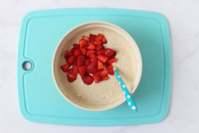 Bowl with pancake mixture and chopped strawberries