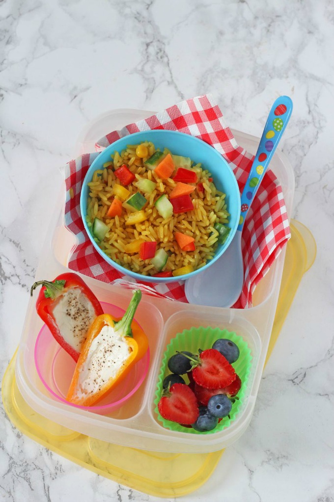 Easy Summer Lunches for Kids - Vegetable rice salad in a blue bowl with a helping of cream cheese stuffed mini peppers and some fresh berries.