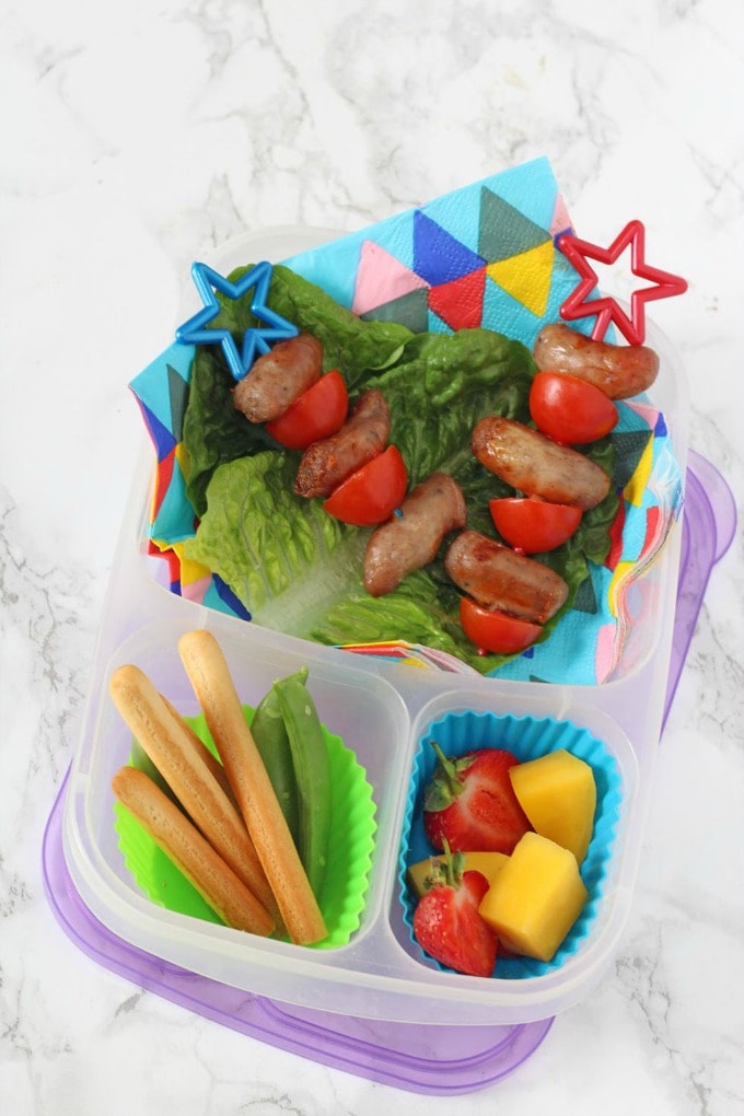 Sausage & Tomato skewers served on a bed of fresh lettuce along side bread sticks and fresh,chopped fruit.