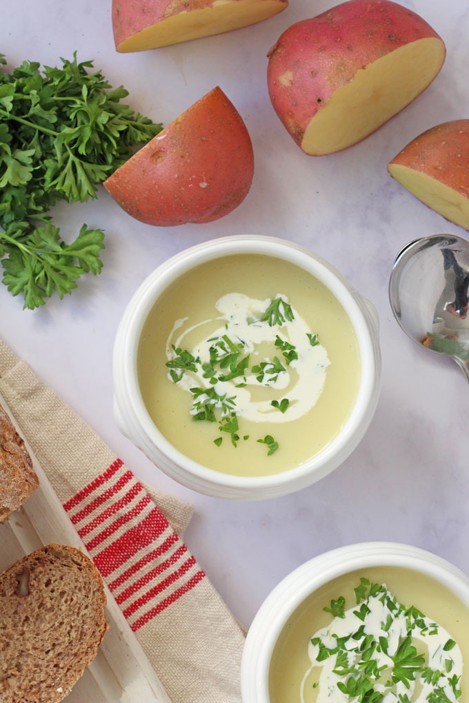 Potato Soup in a white bowl with cream and parsely