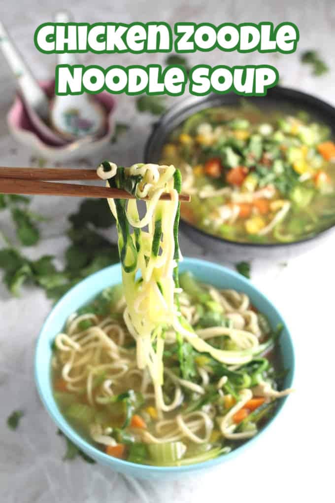 A bowl of chicken zoodle noodle soup with the noodles being taken from the bowl with a pair of wooden chopsticks