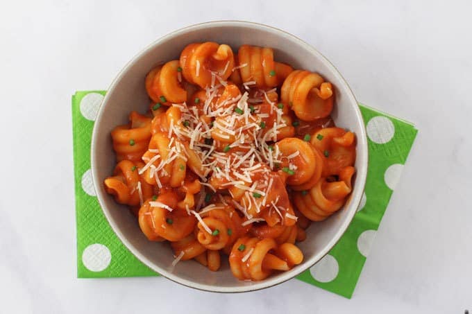 Pasta with red lentil sauce and topped with grated cheese