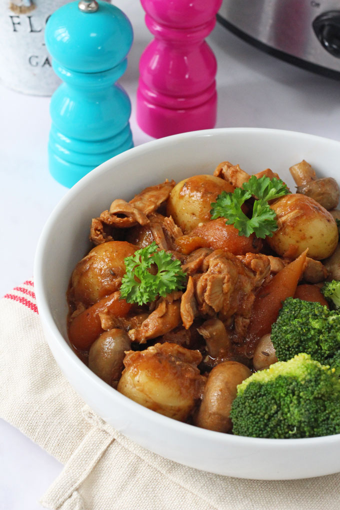 Slow cooker chicken casserole served in a large white bowl with broccoli.