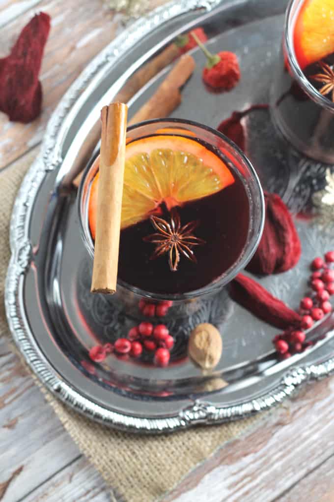 mulled wine in a glass topped with a slice of orange, star anise and a cinnamon stick
