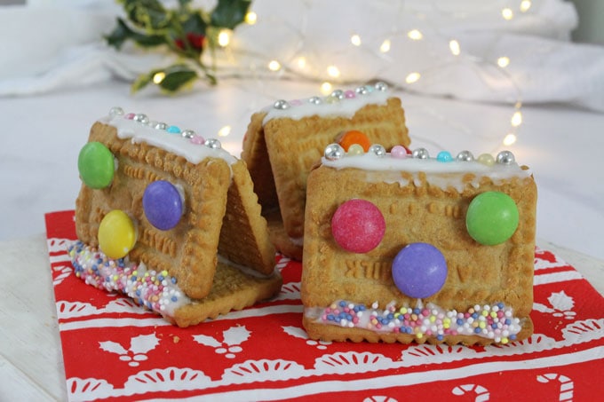 Mini cookie houses decorated with smarties, metallic balls and sprinkles