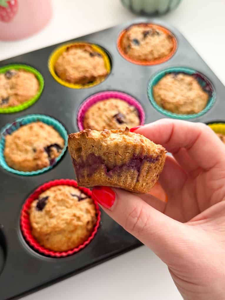 Close up of freshly cooked muffin, and all the other muffins in the back ground in a muffin oven tray.