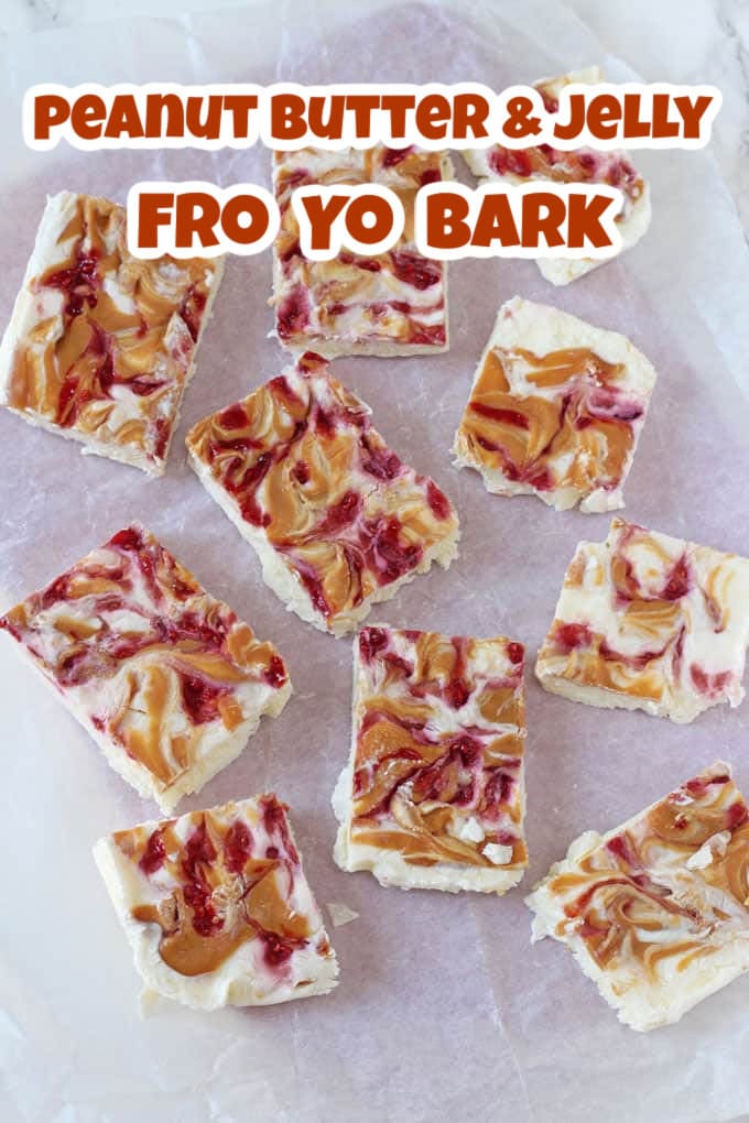 Frozen yogurt bark cut into rectangles laid on top of a sheet of white parchment paper.