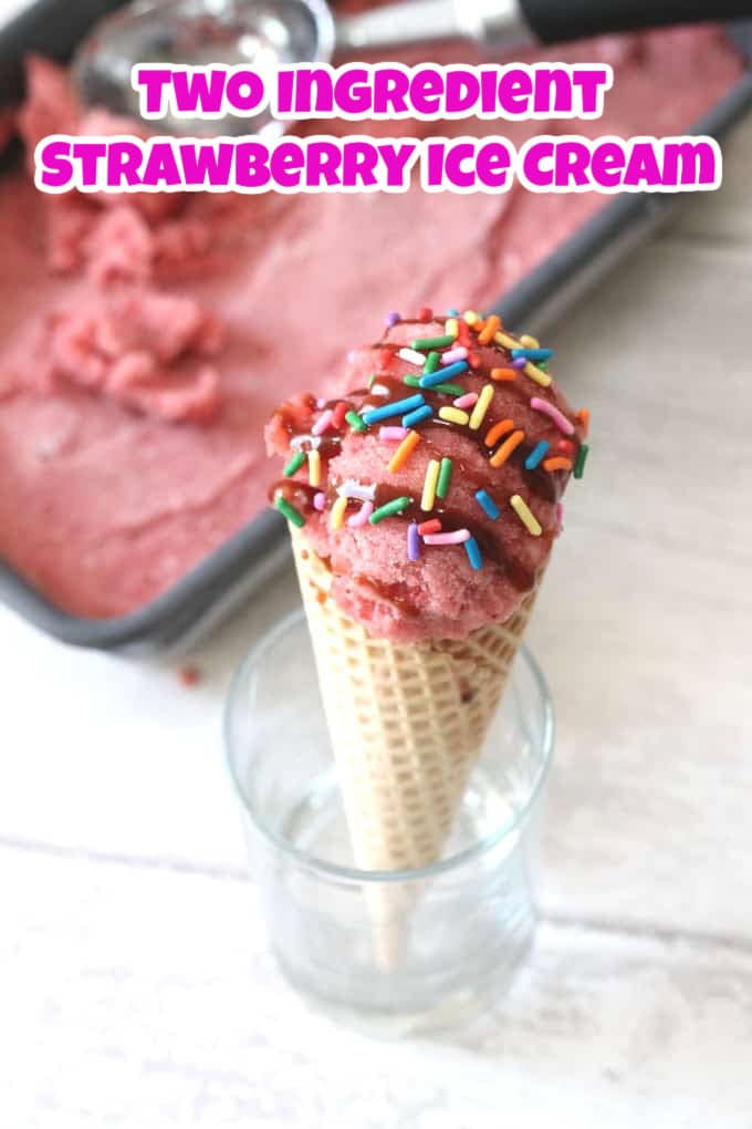 A scoop of strawberry ice cream in a waffle cone topped with strawberry sauce and multicolored sprinkles.