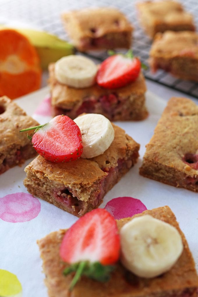 Strawberry & Banana Cake Bars cut into squares and decorated with slices strawberry and banana on top