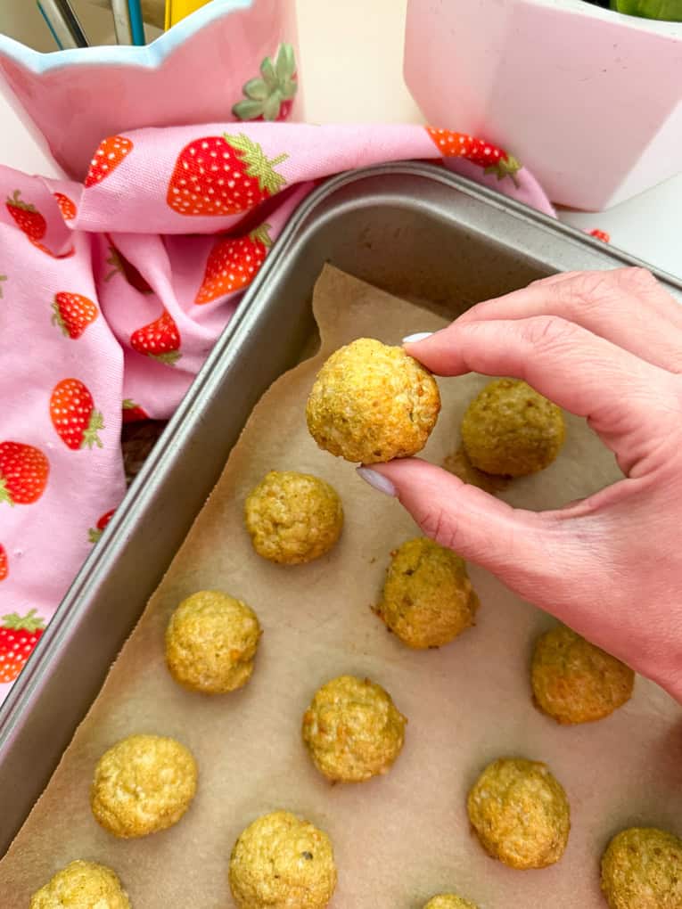 Chicken meatballs arrange on a baking tray on parchment paper.