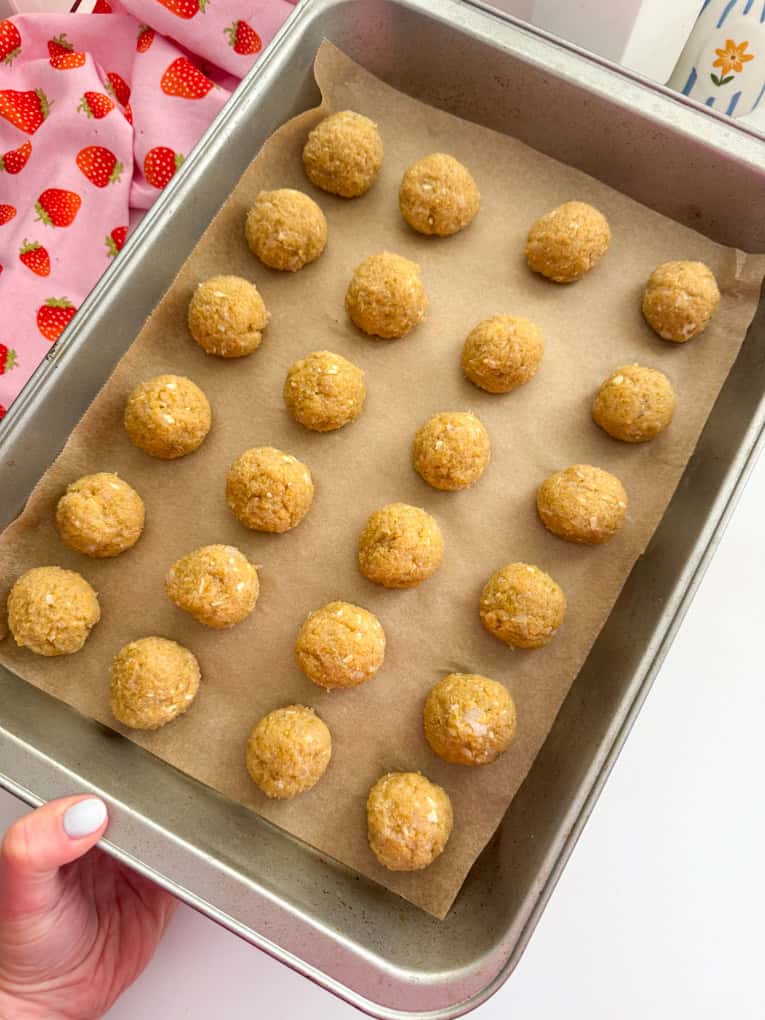 Chicken meatballs arrange on a baking tray on parchment paper.