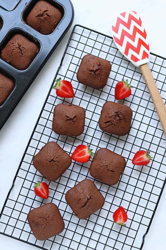 3 Ingredient Brownies on a cooling rack with fresh strawberries and a red and white spatula