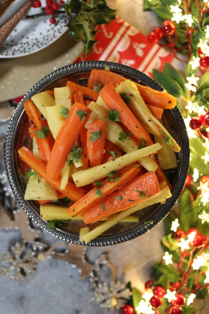 parsnip and carrot batons served in a blue bowl, garnished with freshly chopped parsley.