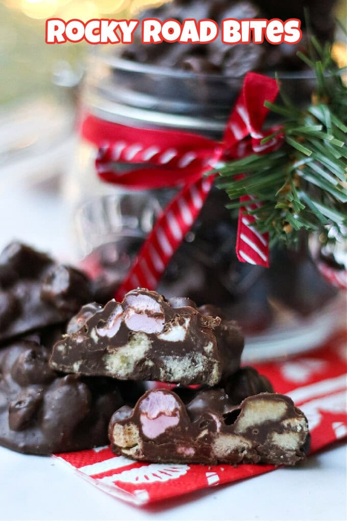 Rocky Road bites cut in half to show the filling with a full kilner jar of bites in the background decorated with festive red and white ribbon.