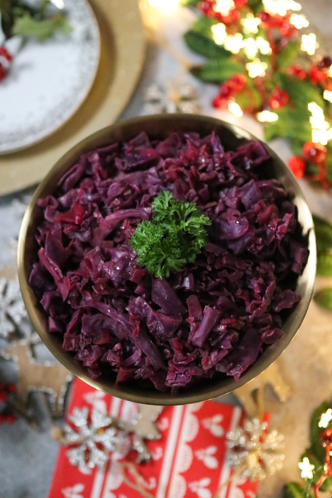 shredded red cabbage served in a gold bowl with fresh parsley on top