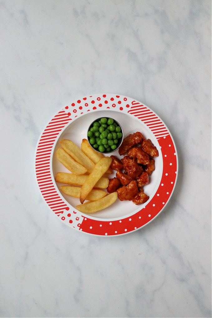 Buffalo chicken served for kids with chips and peas