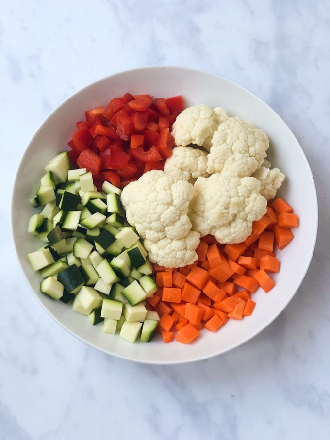 courgette, red pepper, cauliflower and carrot chopped in a bowl
