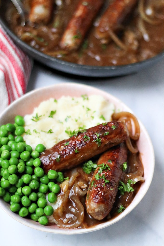sausages served with onion gravy, mash & peas