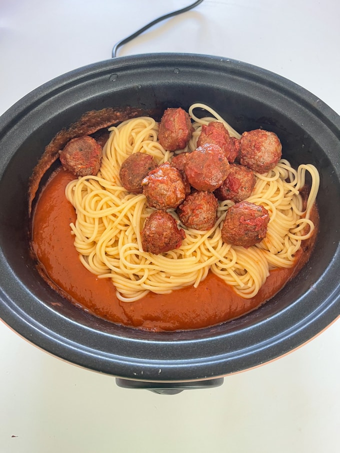 meatballs and spaghetti added to the meatball sauce in the slow cooker