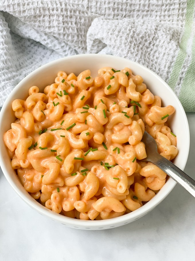 Buffalo Mac & Cheese served in a white bowl, topped with chopped chives