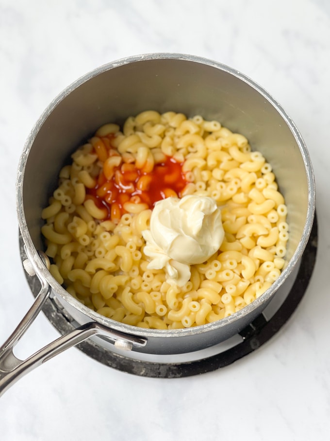 hot sauce, cheese spread and milk added to the cooked macaroni in the saucepan