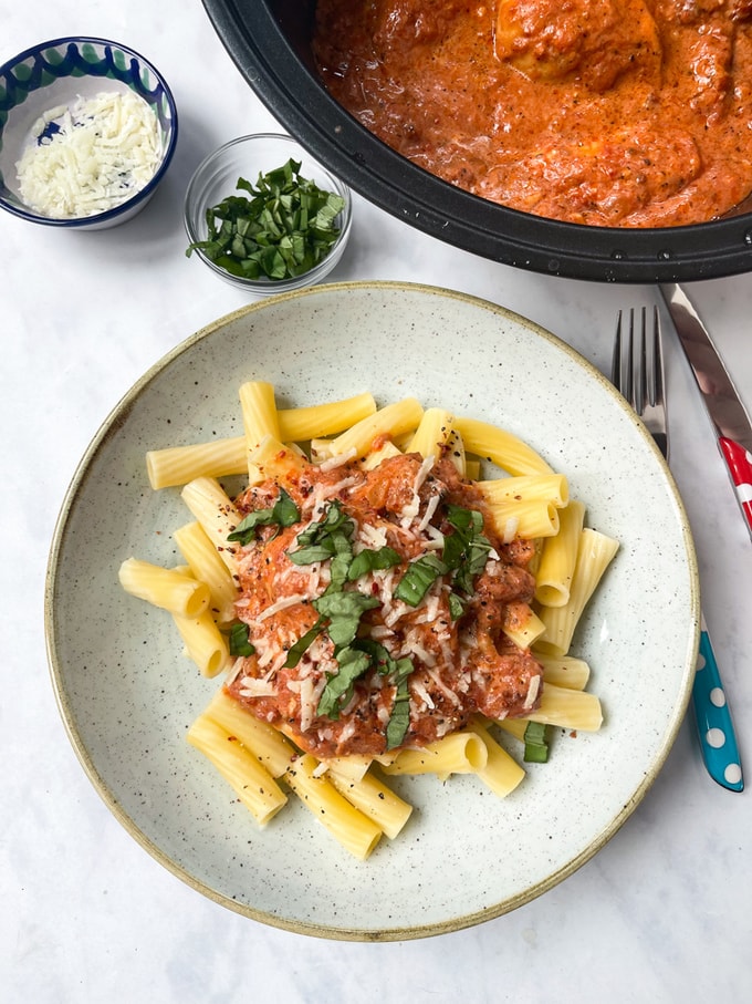 Slow Cooker Sun Dried Tomato Chicken & Pasta on a plate garnished with fresh chopped basil