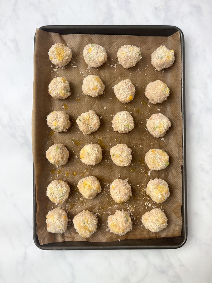 the tune sweetcorn bites all assembled and drizzled with oil on a baking tray ready to be cooked.