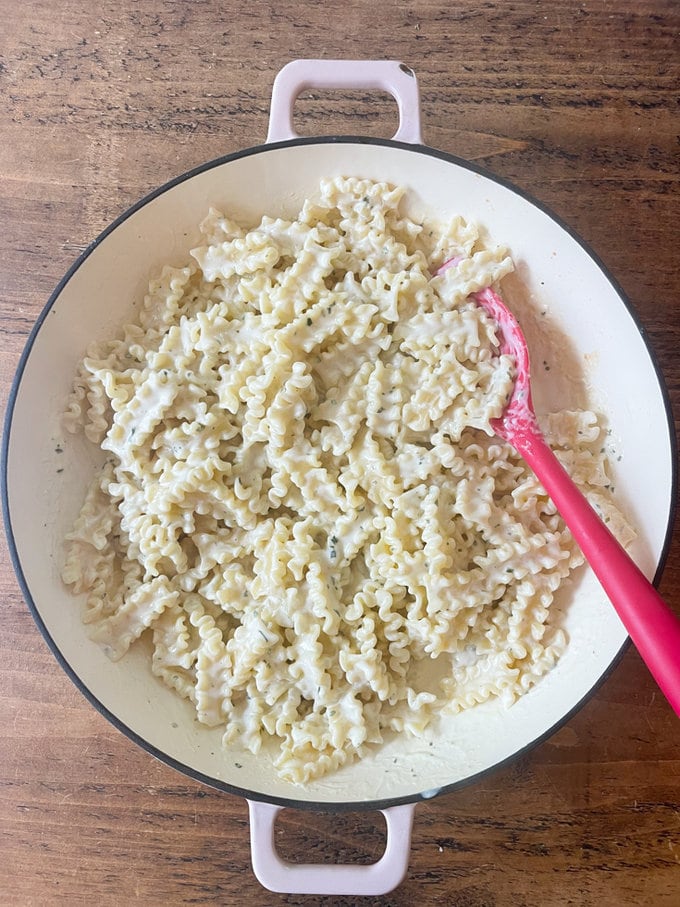 boursin pasta in a large white bowl with a pink pasta spoon