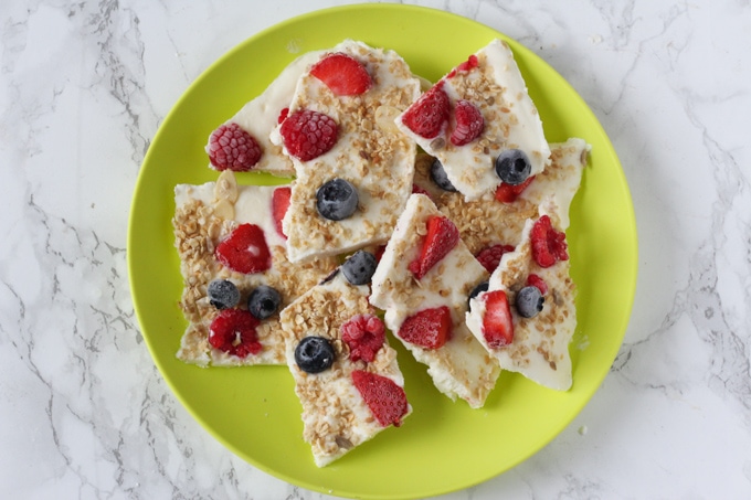 Easy Make-Ahead Breakfast Recipes & Ideas For Kids - Breakfast Frozen Yogurt Bark broken into pieces and served on a green plate