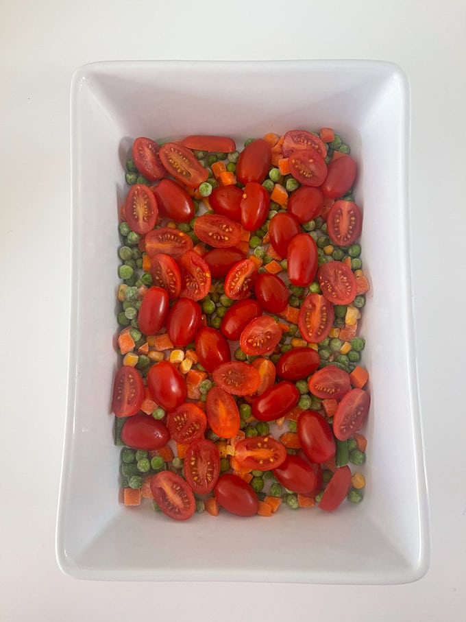 the frozen veggies and cherry tomatoes in an ovenproof dish