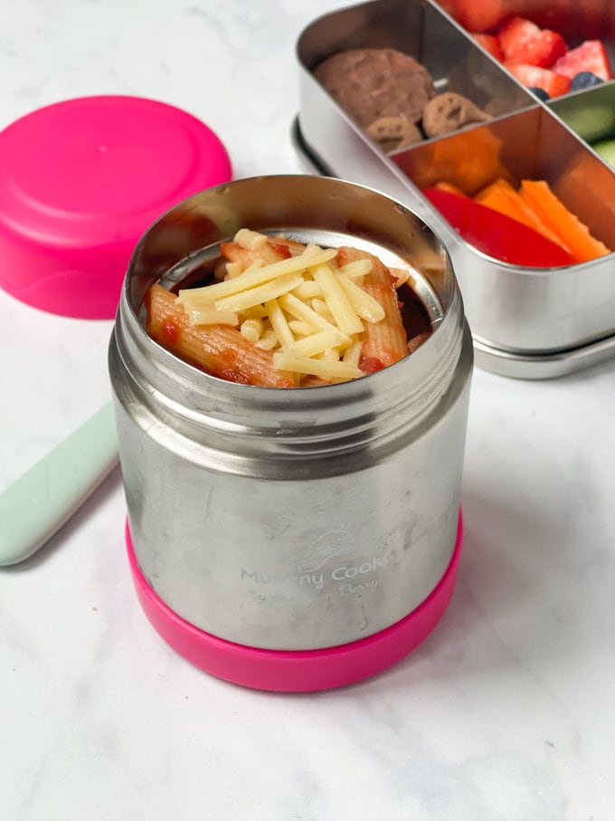 cheese and tomato pasta in a food flask topped with grated cheese