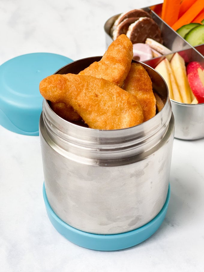 Warm chicken nuggets served in a food flask.