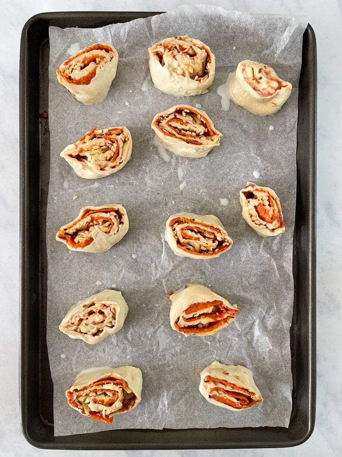 Cut into 12 slices and placed onto a greased baking tray. With milk or egg bushed on top.