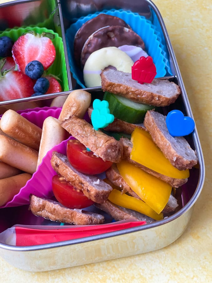 Close up photo of Sausage & veg skewers served on colorful pick sticks.