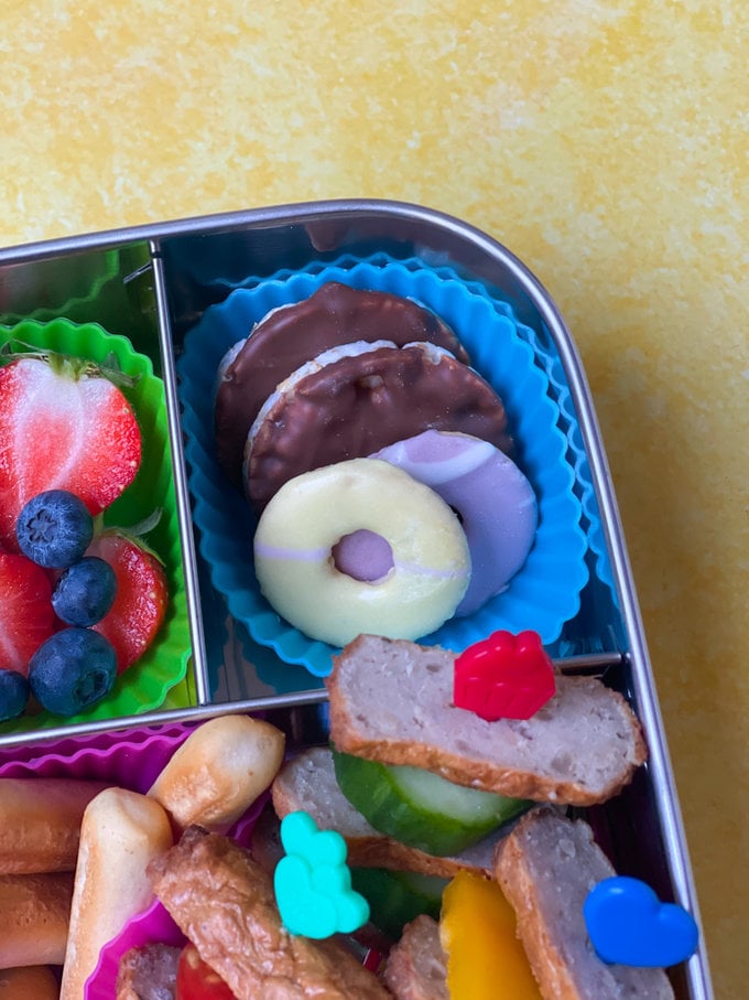 Chocolate rice cakes and party rings severed in a blue cupcake case.