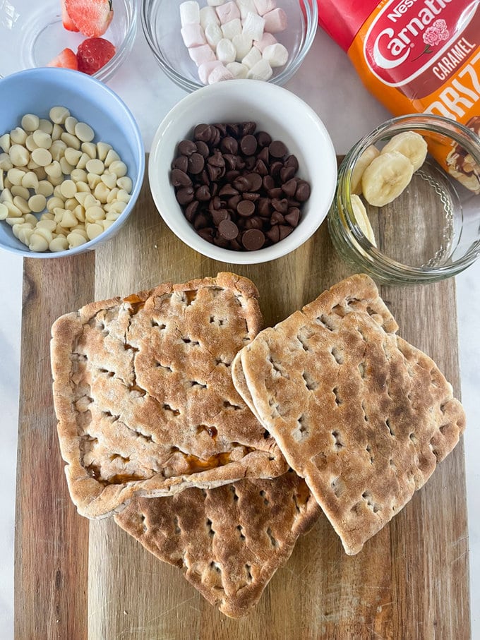 Cooked Toastie displayed on a wooden chopping board along with ingredients used presented in small bowls.