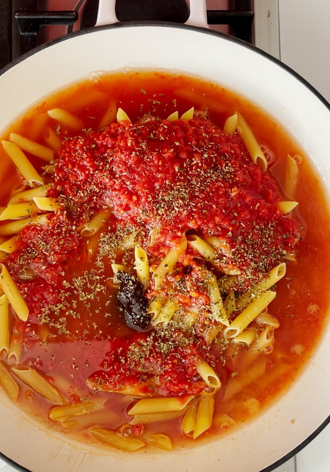 To the same pan add pasta, a tin of chopped tomatoes, vegetable stock, chipotle pasta and dried oregano.