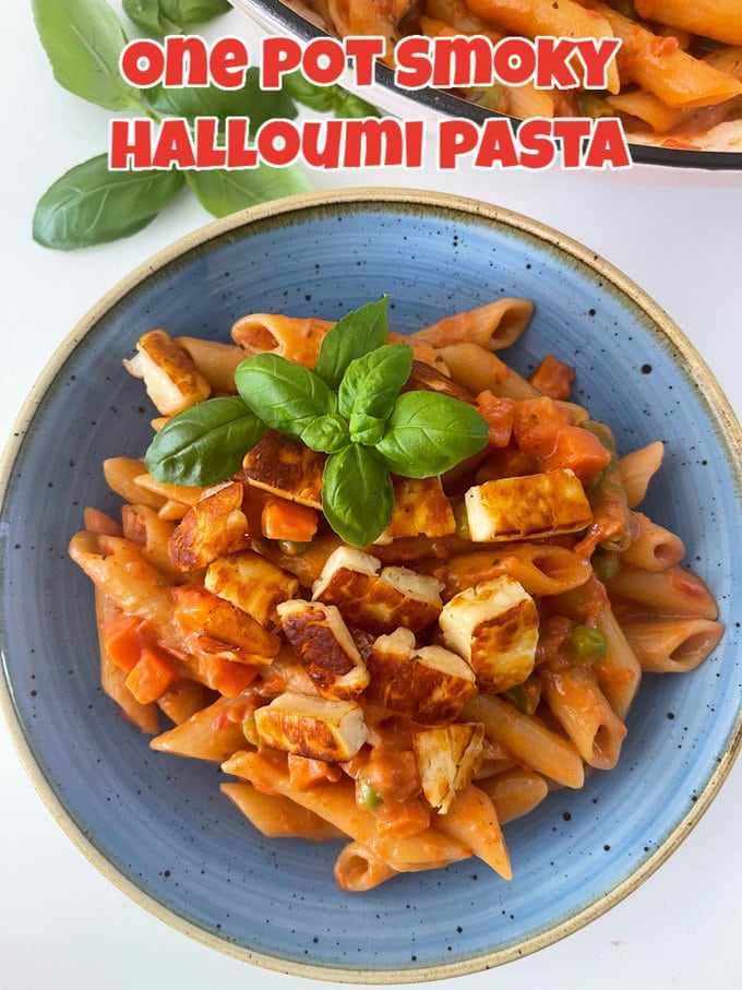 One Pot Smoky Halloumi Pasta served in a blue bowl and garnished with fresh basil leaves