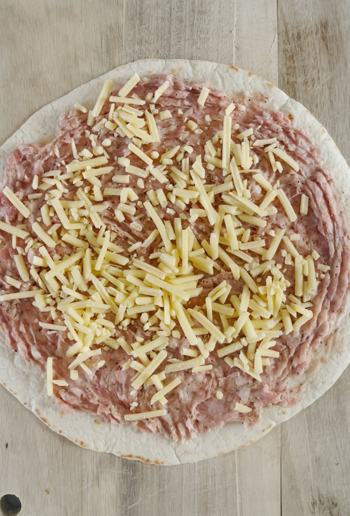 Grated cheese sprinkled onto sausage meat. 