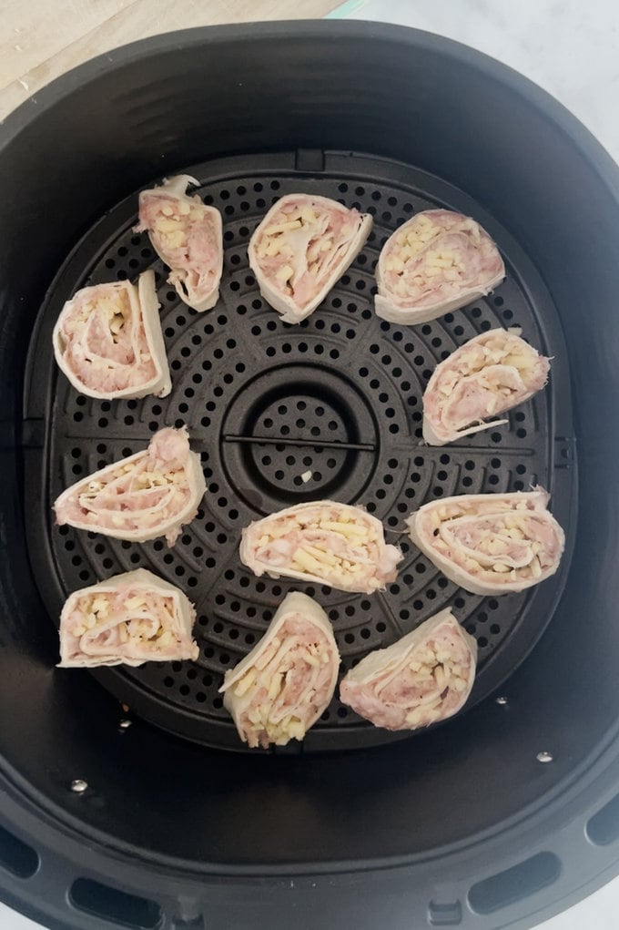 Tortilla pinwheels in the air fryer ready to be cooked.