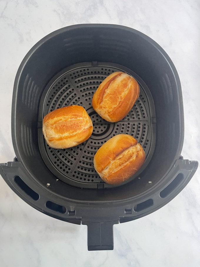 Part baked rolls cooked and sitting the air fryer looking crispy and golden.