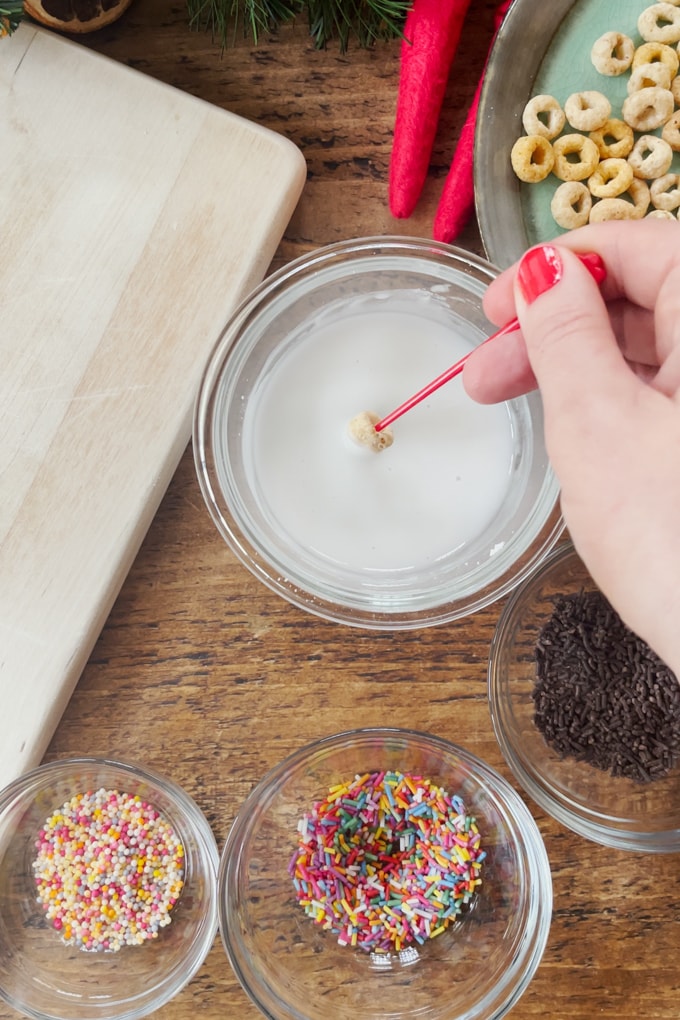 Icing being added to small, hooped cereal.