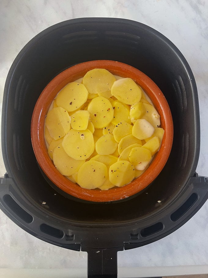 Potatoes in the airfryer drawer, in a round heat proof dish.