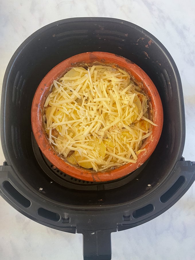 Part way through cooking, Grated cheese is widow to the top.