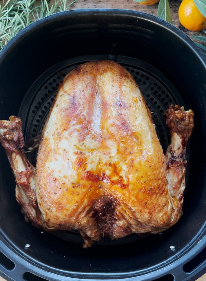 Cooked turkey crown, sitting in the air fryer, looking golden brown and delicious.
