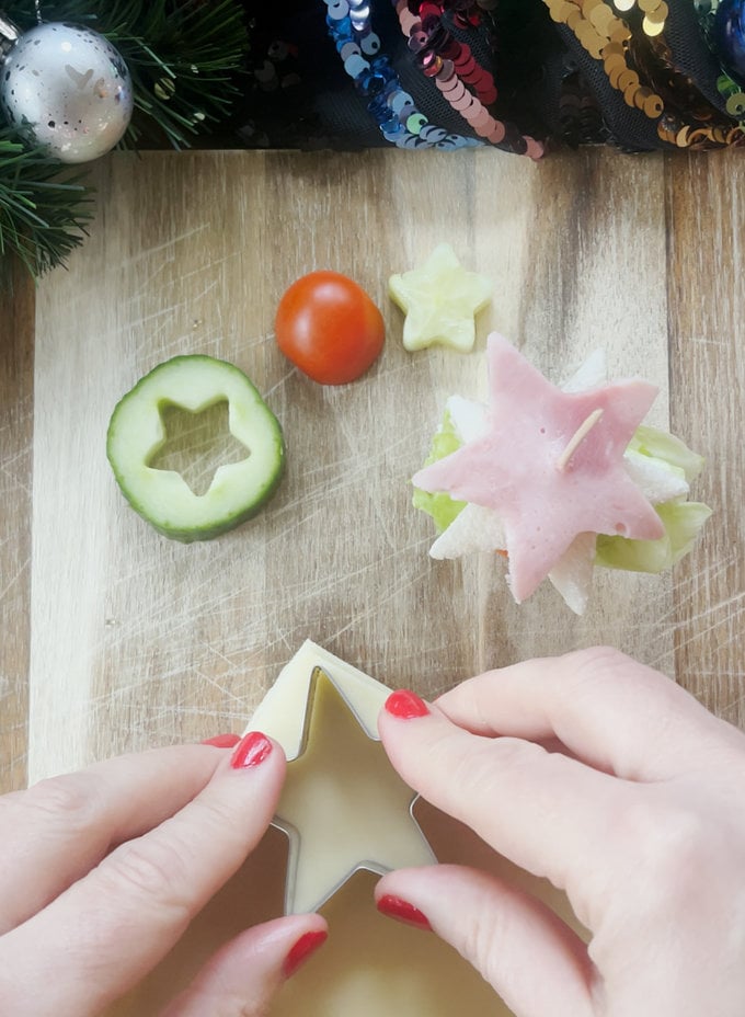 Tree sandwiches being constructed, using a cocktail stick. And a star shaped cookie cutter used to shape the cheese slices.