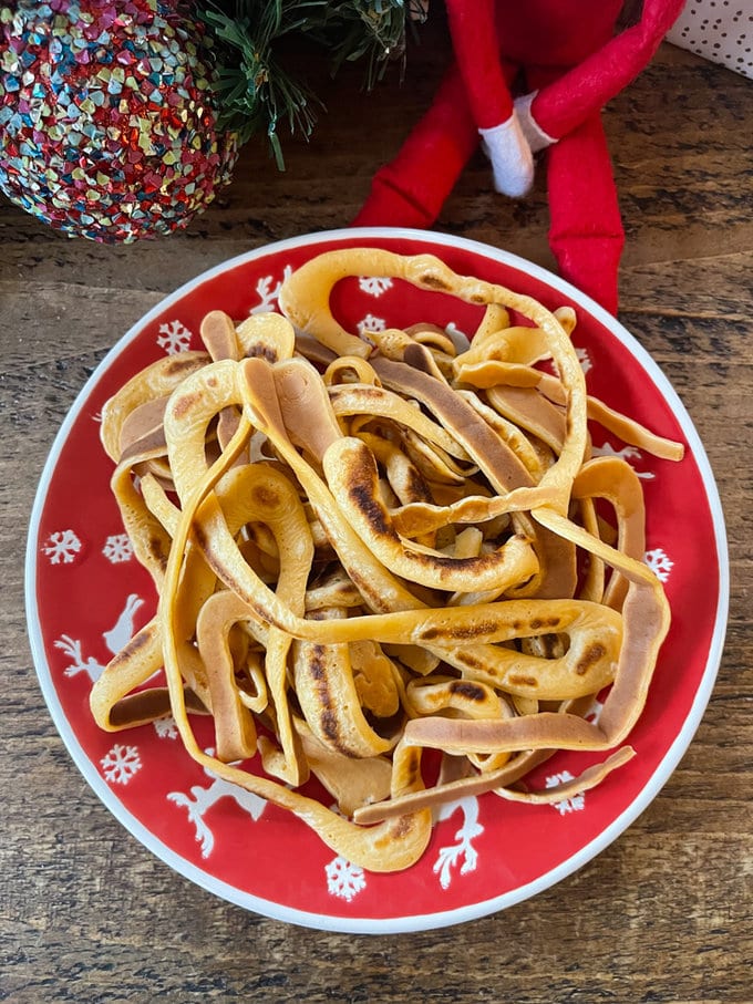 Elf spaghetti is served on a celebratory plate, waiting for toppings to be added. 