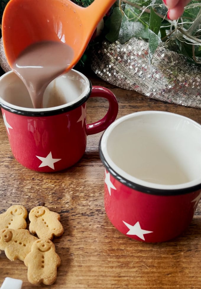 Hot chocolate is poured into the Christmas mugs.