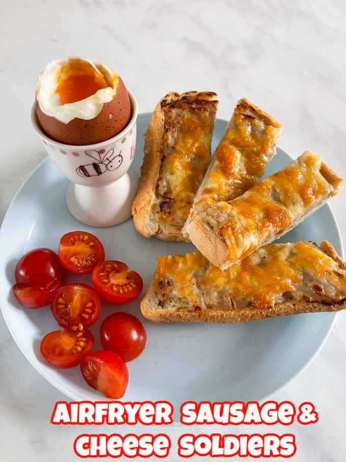 Airfryer Sausage and Cheese Soldiers on a blue plate with a runny boiled egg and some chopped cherry tomatoes