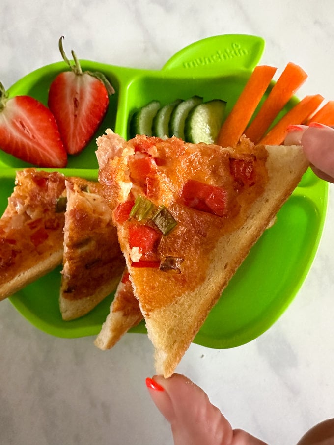 Close up on a triangle shaped piece of the omelette toast.